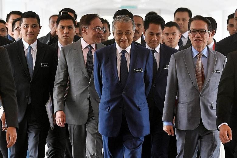 Malaysian Prime Minister Mahathir Mohamad, flanked by Parti Keadilan Rakyat (PKR) president Anwar Ibrahim and Minister in the Prime Minister's Department Liew Vui Keong, arriving for a Parliament session last October. Datuk Seri Anwar is in a bitter 