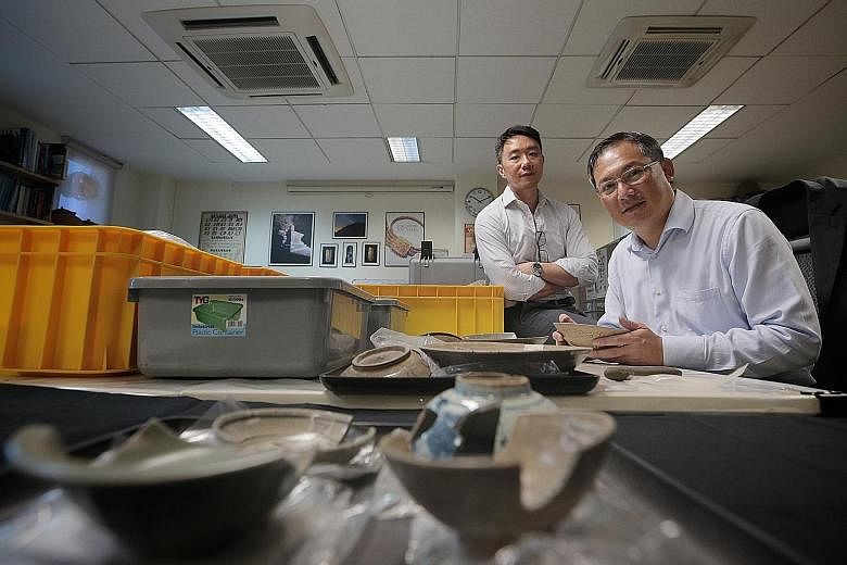 Dr Terence Chong (left), head of the Temasek History Research Centre, and archaeologist Tai Yew Seng, a visiting fellow at the centre, with artefacts from the Empress Place excavation. The centre will get $400,000 a year from the Temasek Foundation f