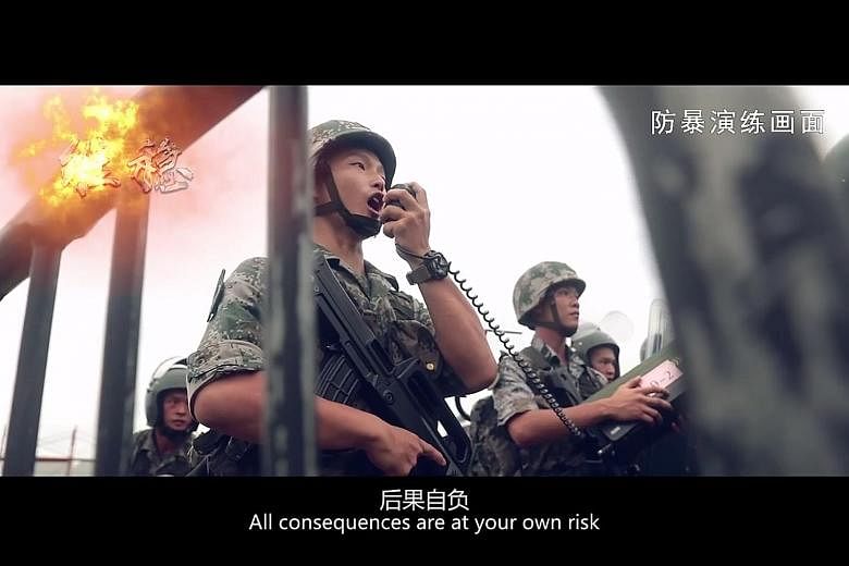 Screengrabs (from top) showing PLA soldiers issuing a warning to "protesters" during an "anti-riot" drill, troops advancing as they fire rifles into the air, and "protesters" being detained by PLA soldiers. The three-minute video was posted on the Ho
