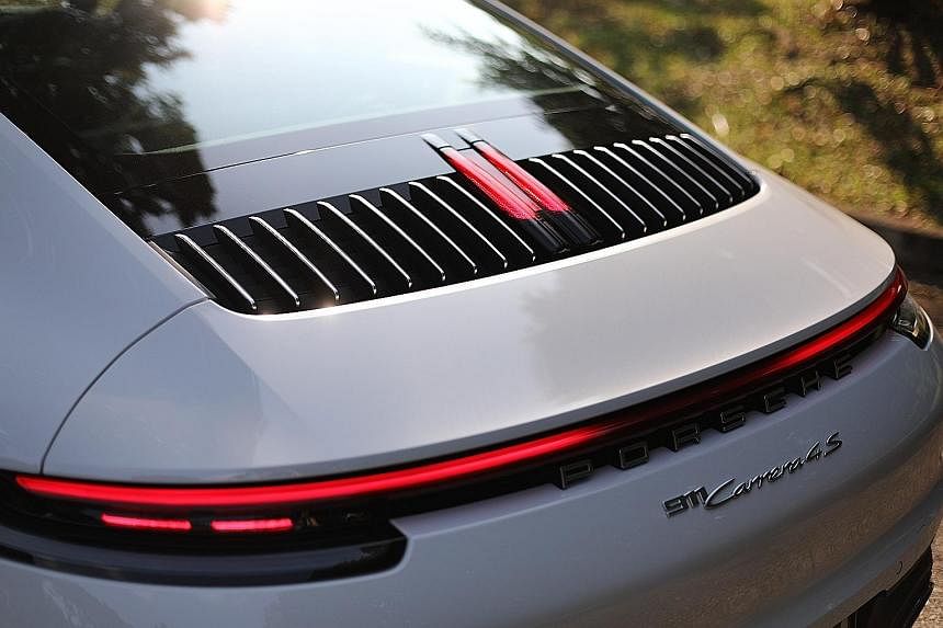 The Porsche 911's iconic front remains largely unchanged, but the rear is adorned with ultra-slim tail-lamp clusters joined by an LED strip. A brake light sits amid vertical louvres which form a nice relief between the rear windscreen and the rear sp