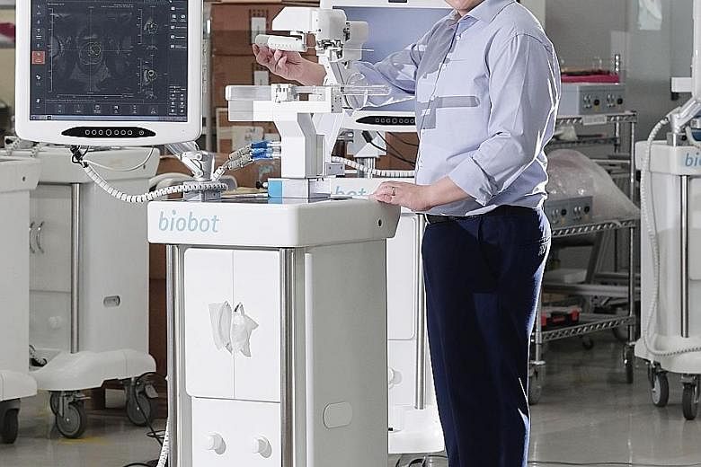 Above: Biobot Surgical chief executive Sim Kok Hwee with a robotic system that can conduct prostate biopsies. The system, developed with Singapore General Hospital, is being used in Singapore hospitals and in Australia and Europe. Left: EndoMaster ch