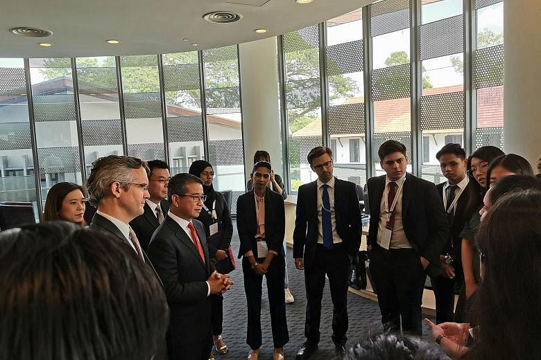Senior Minister of State for Law and Health Edwin Tong (with red tie), with National University of Singapore (NUS) law dean Simon Chesterman (at far left) and Ministry of Law Deputy Secretary Han Kok Juan (behind Mr Tong), interacting with internatio