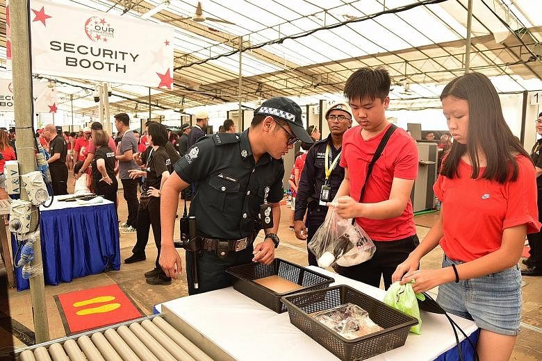 People attending this year's National Day Parade preview at the Padang yesterday having their belongings checked. Security checks will be carried out on everyone entering the venue, including using walk-through metal detectors. Personal belongings wi