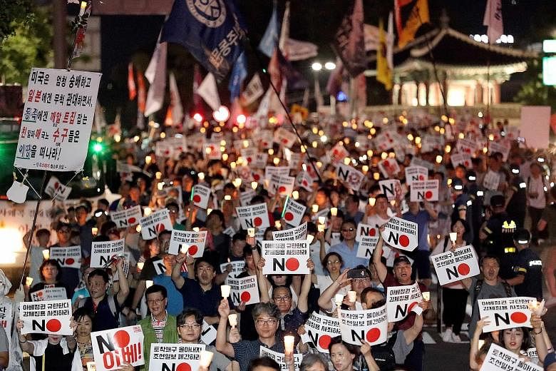 South Koreans holding a candlelight vigil in front of the Japanese Embassy in Seoul yesterday over the two sides' ongoing trade feud.
