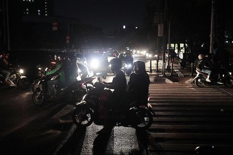 Motorists in Jakarta navigating darkened streets during the massive power outage on Sunday. PHOTO: ASSOCIATED PRESS