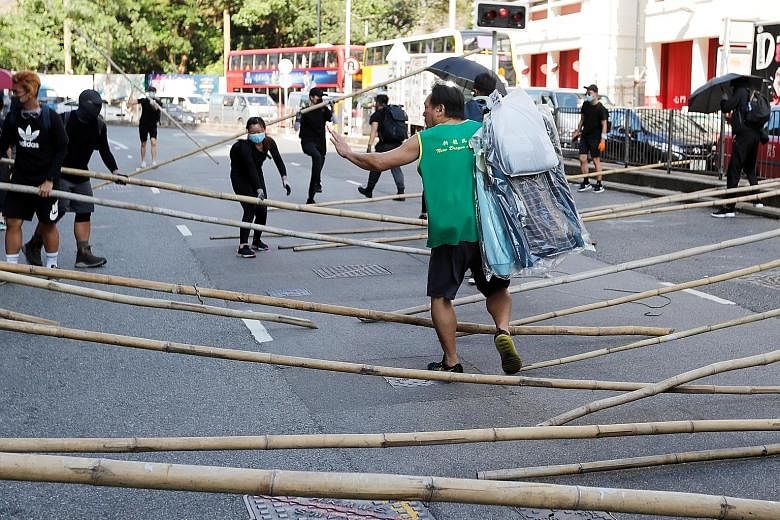 Above: Demonstrators gathering to block the Cross Harbour Tunnel in Hong Kong's Hung Hom district yesterday. Key roads were blocked, cutting major arteries linking Hong Kong Island and the Kowloon peninsula. PHOTO: BLOOMBERG Right: Protesters rushing