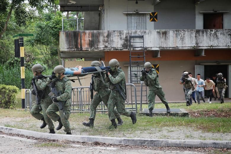 Troops from Singapore and China evacuating "civilians" from the Murai Urban Training Facility yesterday. The raid marked the culmination of this year's 10-day Exercise Cooperation, in which about 120 soldiers from each side took part.