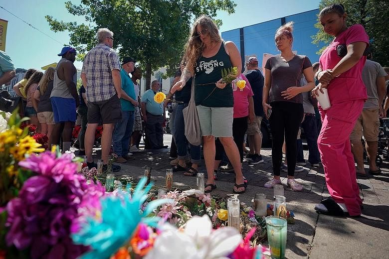 Mourners gathering on Wednesday at the site of Sunday morning's mass shooting, where nine people and the suspect were killed, in Dayton, Ohio.