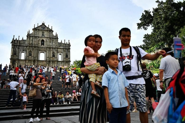 Tourists at the Ruins of St Paul's, officially listed as part of the Historic Centre of Macau, a Unesco World Heritage Site. Many visitors are steering clear of the world's biggest gambling hub, worried over transport disruptions and safety concerns 