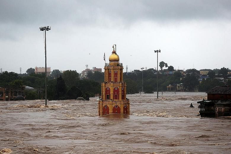 A temple partially submerged in the waters of the overflowing Godavari River following heavy rain in Nashik city in India's Maharashtra state, where the death toll from the floods hit 25.