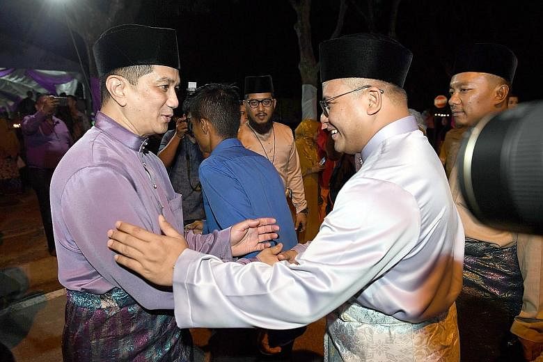 In this file photo of a Hari Raya event on June 30, Economic Affairs Minister Azmin Ali (left) and Selangor Menteri Besar Amirudin Shari are seen exchanging greetings. PHOTO: BERNAMA