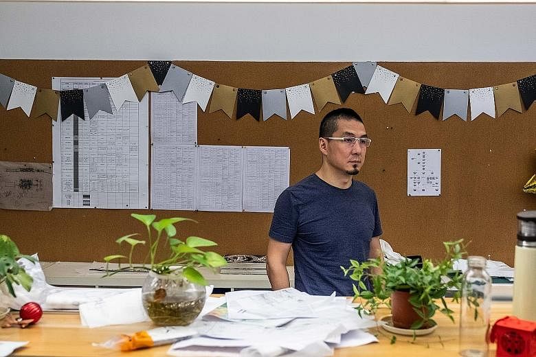 Mr Zhang Zhiyang at his architecture firm in Shenzhen. He is now accepting the financial equivalent of IOUs from as many as one-third of his clients instead of cash, with China's economy and his own business slowing. PHOTO: NYTIMES