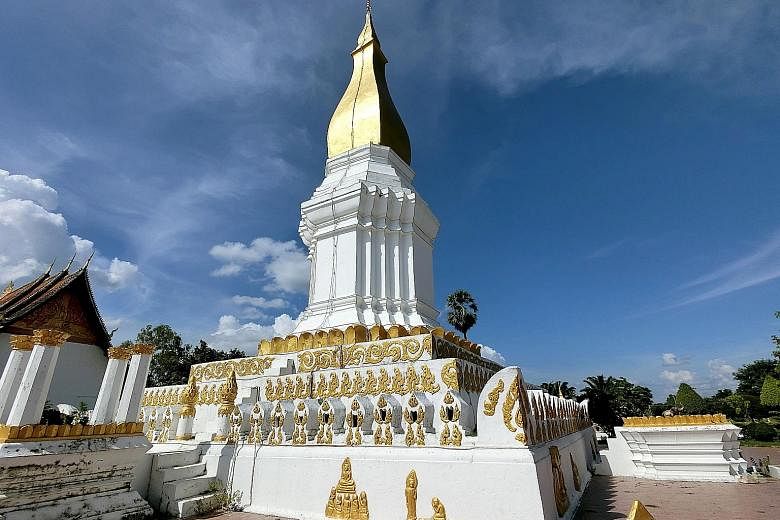 (Above) A traditional Baci ceremony at Wat Phabath in the Bolikhamxay Province, where a monk ties a piece of string on a person's wrist as a blessing.(Right) The Sikhottabong Stupa in Thakhek is a revered sacred site with an impressive 29m-tall golde
