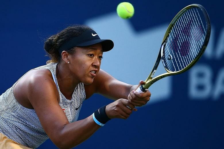 Naomi Osaka hits a return against Serena Williams during their Rogers Cup quarter-final on Friday. The Japanese had no answers to her opponent's 31 winners, however, as the American won in straight sets. PHOTO: AGENCE FRANCE-PRESSE