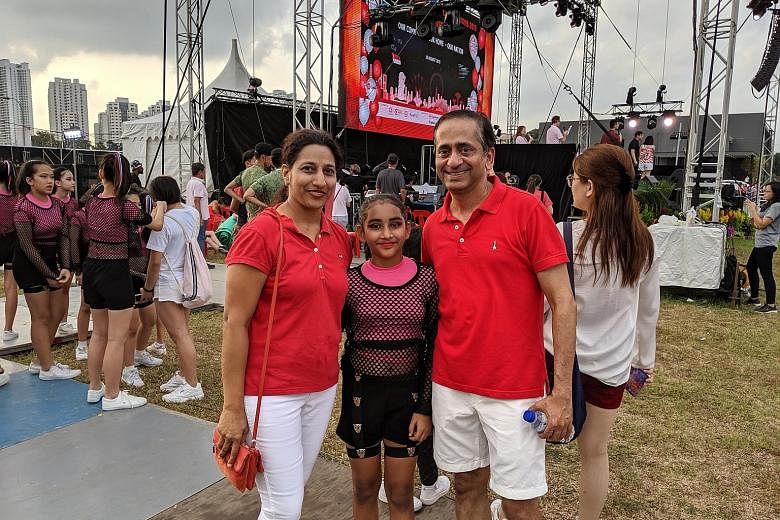 Mr Chetan Samel, 46, his wife Aparna, 42, and their daughter Saloni, 11, who performed at the National Day celebrations in Bishan yesterday. Mr Samel said he enjoyed the carnival as it was well organised and lively. Fireworks lighting up the sky near