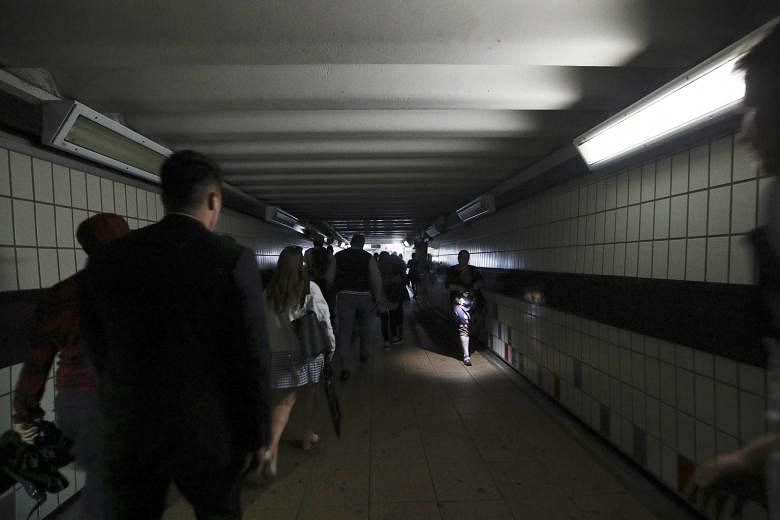 Commuters walking in near darkness at Clapham Junction station during a power blackout on Friday which left London and a large chunk of Britain without electricity, disrupting train travel and snarling rush-hour traffic.