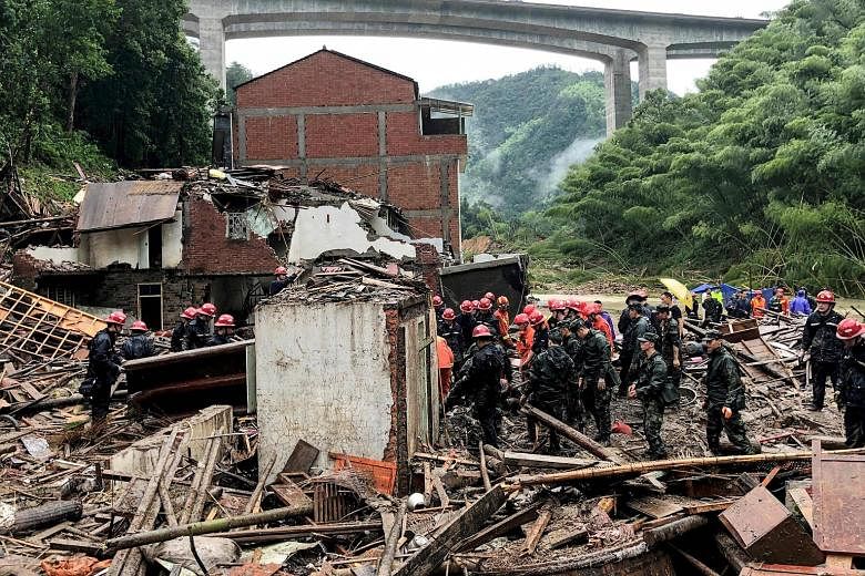 Rescuers and paramilitary police officers searching for survivors in the rubble of damaged buildings after torrential rain caused by Typhoon Lekima in Wenzhou, China's eastern Zhejiang province, yesterday. The death toll rose to 32, with 16 people mi
