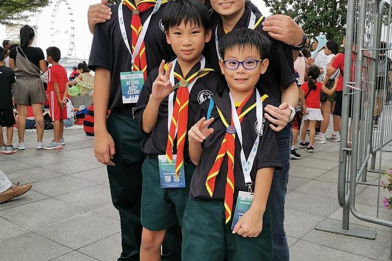 Mr Caleb Teo, his wife, Ms Shu Yi Ping, 41, and their sons (from left) Isaiah, Zechariah and Jedidiah went to the Padang area not to catch the NDP but to help keep the place litter-free. PHOTO: NATIONAL ENVIRONMENT AGENCY