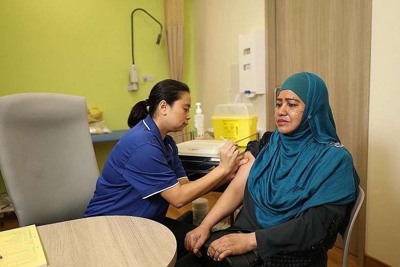 Keat Hong Family Medicine Clinic's assistant nurse clinician Chris She attending to Madam Maimunah Abu Baker, who takes a 10-minute walk to Keat Hong Community Club for her cancer treatments.
