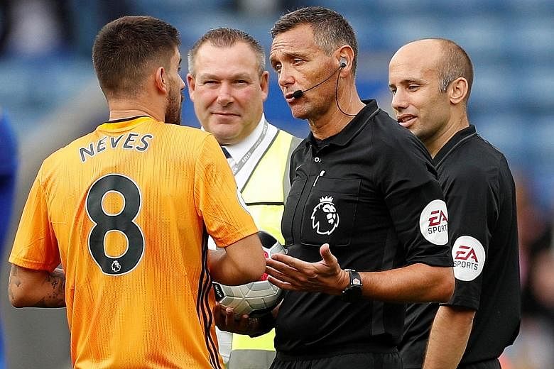 Wolves midfielder Ruben Neves protesting referee Andre Marriner's decision to rule out a goal following a VAR review. PHOTO: REUTERS