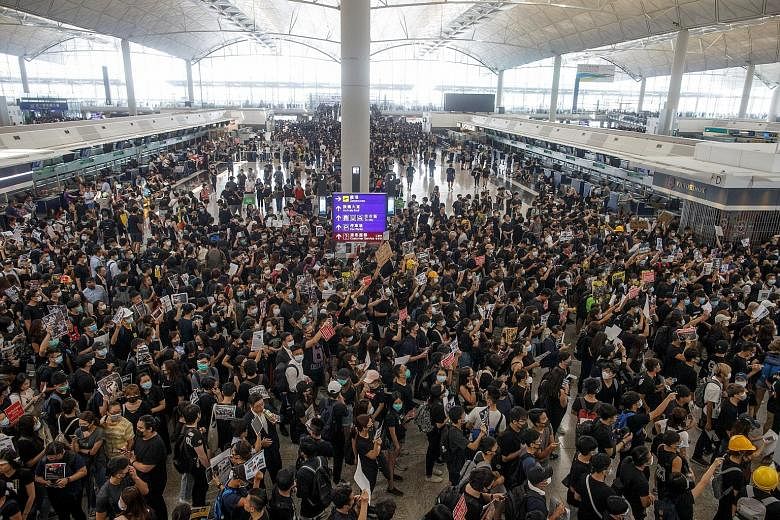 Protesters swarming the departure hall of Hong Kong airport yesterday, the fifth continuous day that they have occupied the facility. PHOTO: REUTERS