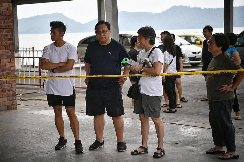 Above: Malaysian officials giving an update yesterday on the search for Mr Tan Eng Soon and Madam Puah Geok Tin, who went missing last Thursday. Left: Madam Puah's husband, Mr Peng Mun Kit (in black) and their son Louis (far left) at the Penyabong je