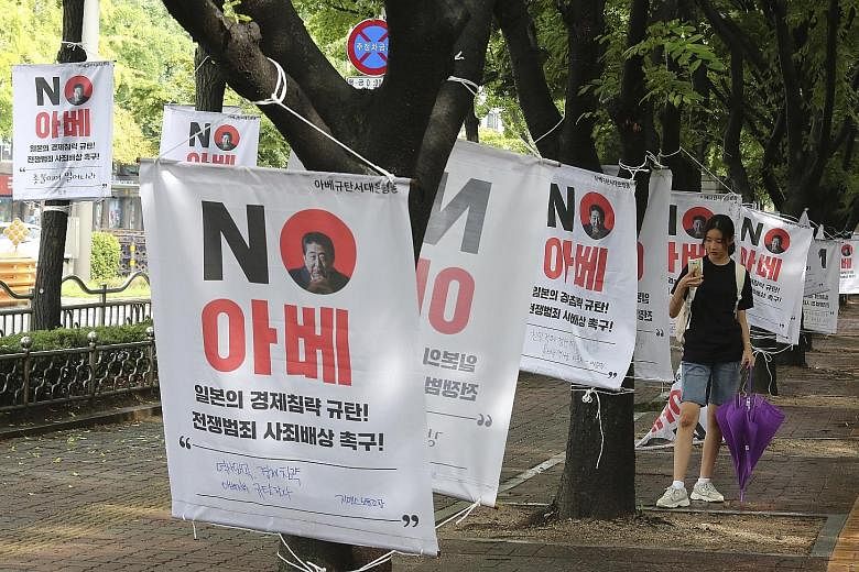 Banners, with Japanese Premier Shinzo Abe's image, denouncing Japan's trade curbs on South Korea on a street in Seoul. PHOTO: ASSOCIATED PRESS
