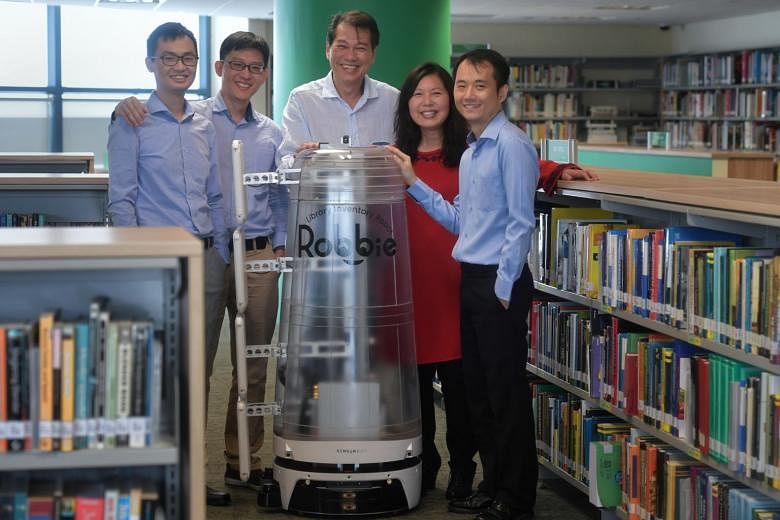 Senserbot team members (from left) vice-president for research and development Li Renjun, chief technology officer Ho Chin Keong and chief executive Peter Mao, with Temasek Polytechnic's library director Puspa Yeow and librarian Tan Han Yong. Robbie's cas