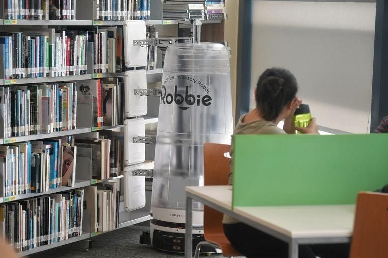 Robot Robbie at work in Temasek Polytechnic's library. The workhorse saves library officers 16 man-hours a day so they can undertake less tedious work.