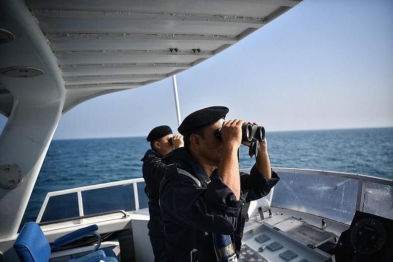 Rescuers from the Malaysian Maritime Enforcement Agency on a boat yesterday, scanning the sea with high-powered binoculars. ST PHOTO: ARIFFIN JAMAR