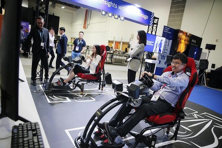 Visitors trying out a driving simulator at IBM Think Singapore yesterday. More than 1,000 business leaders and experts gathered for the one-day conference to discuss how companies around the world were using cutting-edge technology to transform their