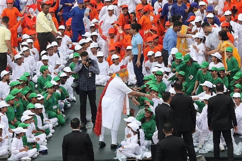 Indian Prime Minister Narendra Modi (centre) greeting schoolchildren during Independence Day celebrations in New Delhi yesterday. PHOTO: EPA-EFE