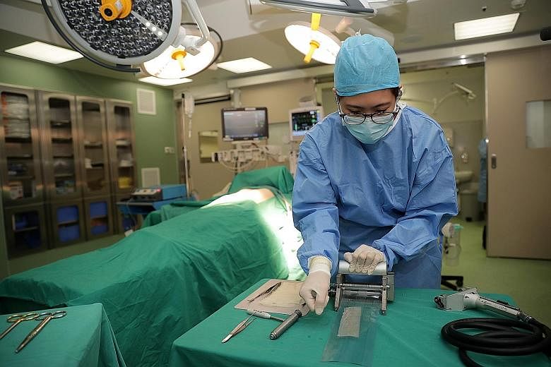Senior resident Grace Tan, 29, with the Singapore General Hospital department of plastics, reconstructive and aesthetics surgery, meshing skin as part of a skin-grafting operation. The SGH Burn Centre, which first opened in 1962, is the major burns r
