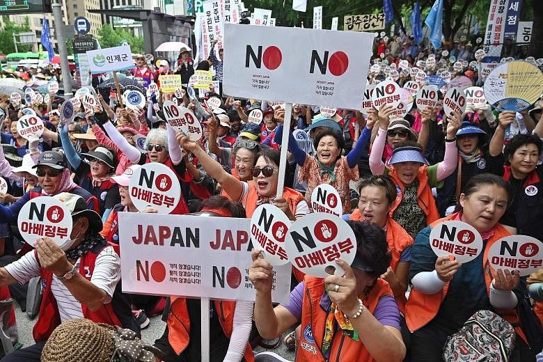 South Korean protesters holding up signs reading "No Abe's government", referring to Japan's Prime Minister Shinzo Abe, during an anti-Japanese rally in central Seoul on Tuesday.