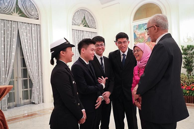 President Halimah Yacob and her husband, Mr Mohamed Abdullah Alhabshee, with this year's President's Scholarship recipients (from far left) Allison Tan Sue Min; Siow Mein Yeak, Yue; John Chua Je En; and Muhammad Dhafer Muhammad Faishal at the Istana 
