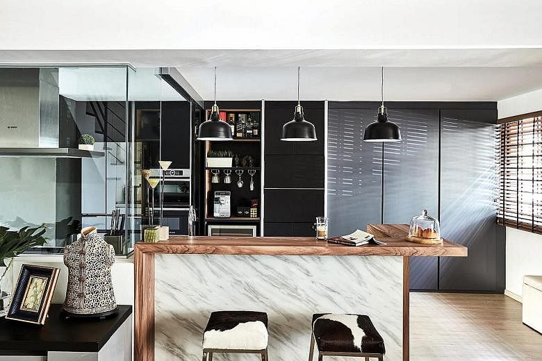 The marble and wood counter is where the family hangs out when the younger son demonstrates his culinary skills.