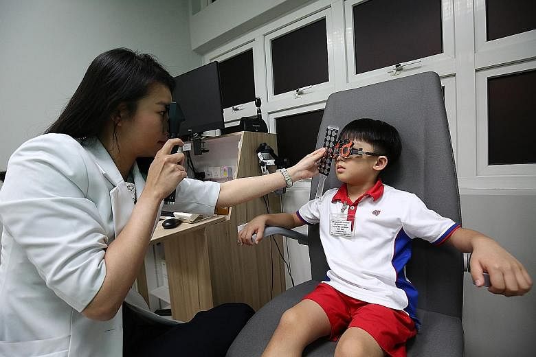 An optometrist at the Bedok North myopia centre carrying out an eye test on a child from PCF Sparkletots yesterday. The clinic, which opened yesterday, will provide comprehensive care, especially for patients suffering from high myopia, and at the sa