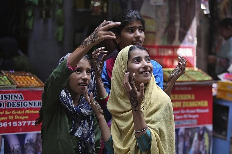 Girls with henna decorations to mark Eid al-Adha in Jammu last week. The Indian government said it eased restrictions for the festival. A New York Times image showing demonstrators outside Srinagar on Friday. Ongoing news reports of civilian victims 