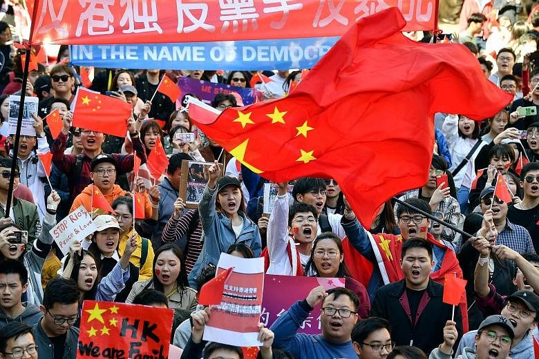 Protesters carrying umbrellas taking part in a march themed "Recover Hung Hom" in Hong Kong yesterday. Hung Hom and To Kwa Wan are popular areas for low-cost travel tourists from mainland China. PHOTO: EPA-EFE Pro-China activists bearing Chinese flag