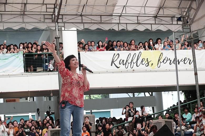 Left: Raffles Girls' School alumna Kit Chan performing in the school amphitheatre at its Anderson Road campus yesterday. Above: Mrs Ivy Kwa (left), 93, and Mrs Betty Chen, 92, both from the Class of 1941, at the homecoming event. ST PHOTOS: KELVIN CH