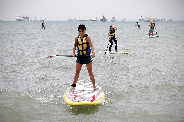 Ms Jessica Wee (foreground) heading back to shore after a session with the stand-up paddling interest group at East Coast Park. ST PHOTO: NEO XIAOBIN