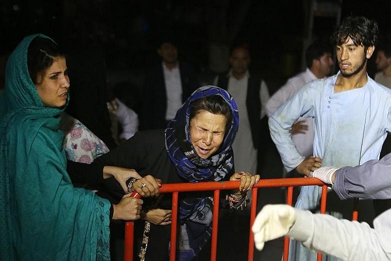 A grieving Afghan woman, who lost her husband and two sons, after a suicide attack on a wedding party in Kabul last Saturday. The strike underscores in part the inadequacy of Afghanistan's security forces. Workers inspecting the wedding hall yesterda