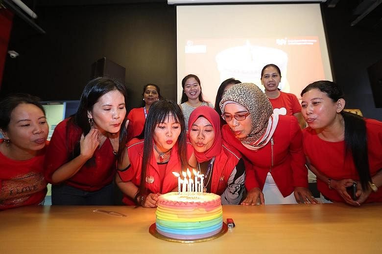 Indonesian Siti Mur Wati Bawel (third from left), who turns 41 today, joined other maids with August birthdays as well to blow out candles and cut a rainbow sponge cake yesterday.