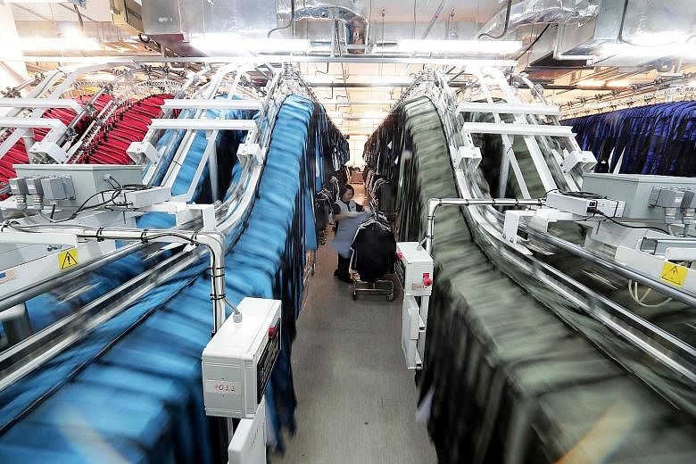 Staff uniforms being loaded onto conveyor belts in Marina Bay Sands' wardrobe room. Some 160,000 uniforms, which can be tracked with sewn-in radio frequency identification tags, are identified and collected by staff in half a minute, with just a swip