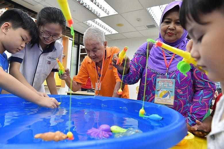 It's time for "fishing" as Mr Ong Kim Hon takes part in a game with students from San Yu Adventist School (SYAS) and others yesterday morning. Mr Ong, who is in his 70s and a resident of the Adventist Home for the Elders, was among the 90 elderly ben
