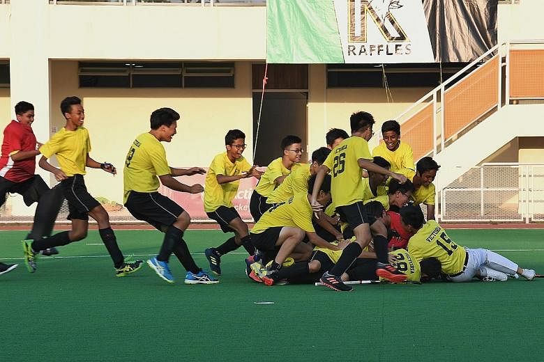 Victoria School's hockey players celebrate after winning a marathon penalty shoot-out against Raffles Institution to claim the Schools National C Division boys' hockey gold. ST PHOTO: KHALID BABA