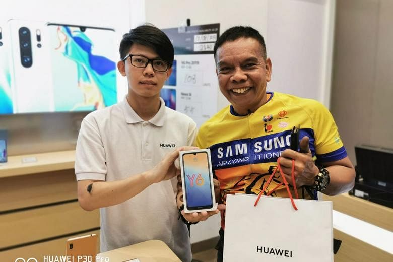 Mechanic Salehim Aman showing the Y6 Pro smartphone he bought with the $100 voucher at Huawei Jurong Point on Aug 13. He feels lucky that he is paying less than the original offer. PHOTO: HUAWEI