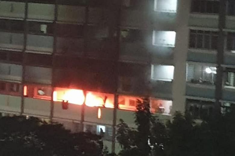 Thick plumes of smoke from a fire at a Jurong West Housing Board flat on Sunday. The SCDF rescued a woman from the flat's kitchen ledge, and she and three others were taken to hospital.