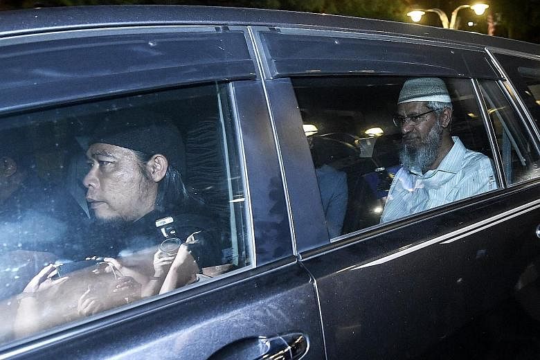 Dr Zakir Naik (back seat) being driven from the headquarters of the Royal Malaysian Police in Kuala Lumpur yesterday, after giving a statement to aid in police investigations into his racially charged comments.