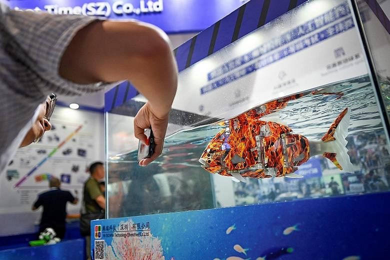 A visitor using his smartphone to take a picture of a robofish at the 2019 World Robot Conference in Beijing yesterday. On until Sunday, the event has drawn over 180 robotics enterprises that are showcasing their more than 700 new products. The confe